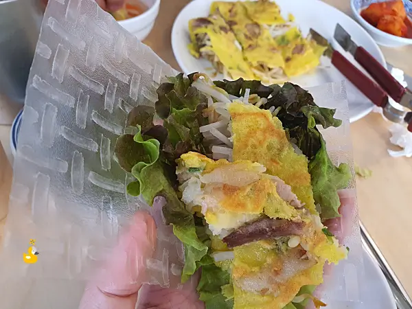 쌀종이 위에 상추와 반쎄오를 얹은 사진
