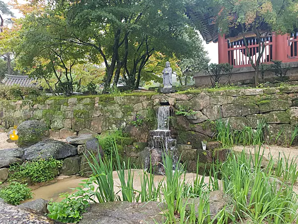 작은 관세음보살 불상이 있는 귀여운 연못