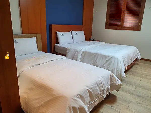 싱글 침대와 더블 침대가 놓여 있는 호텔 방