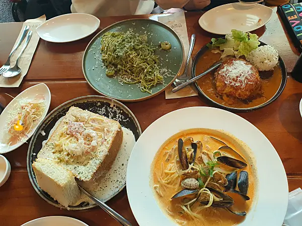 바질파스타, 함박스테이크, 빠네크림스파게티, 마라 해물 파스타가 올려져 있는 테이블