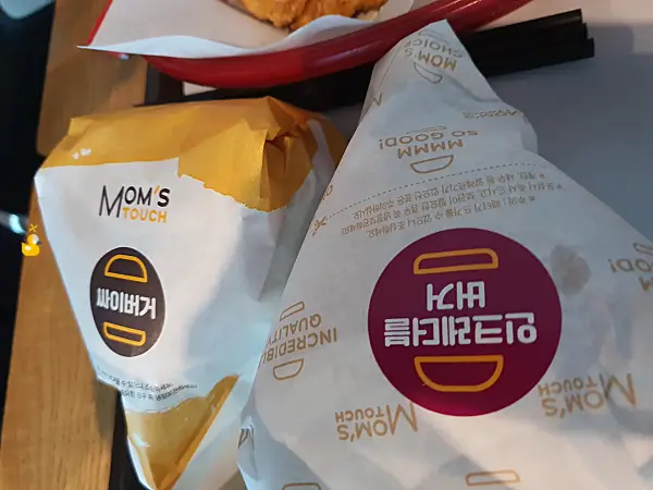 맘스터치의 싸이버거와 인크레블버거가 포장지에 포장되어 있는 사진
