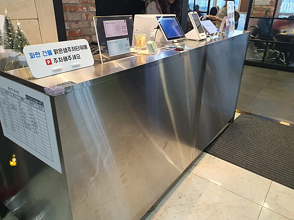 주차 정보와 카드단말기 등이 올려져 있는 울산 샤브샤브 맛집 와봄 계산대