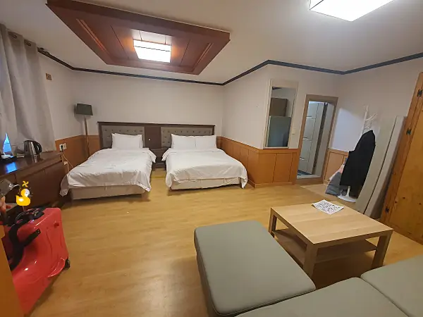 홍천 모둘자리 4인 숙소 입구에 들어서자마자 보이는 침대와 소파, 옷걸이