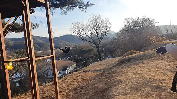 홍천 모둘자리 어드벤처로 500m 짚라인을 타고 내려가는 사람