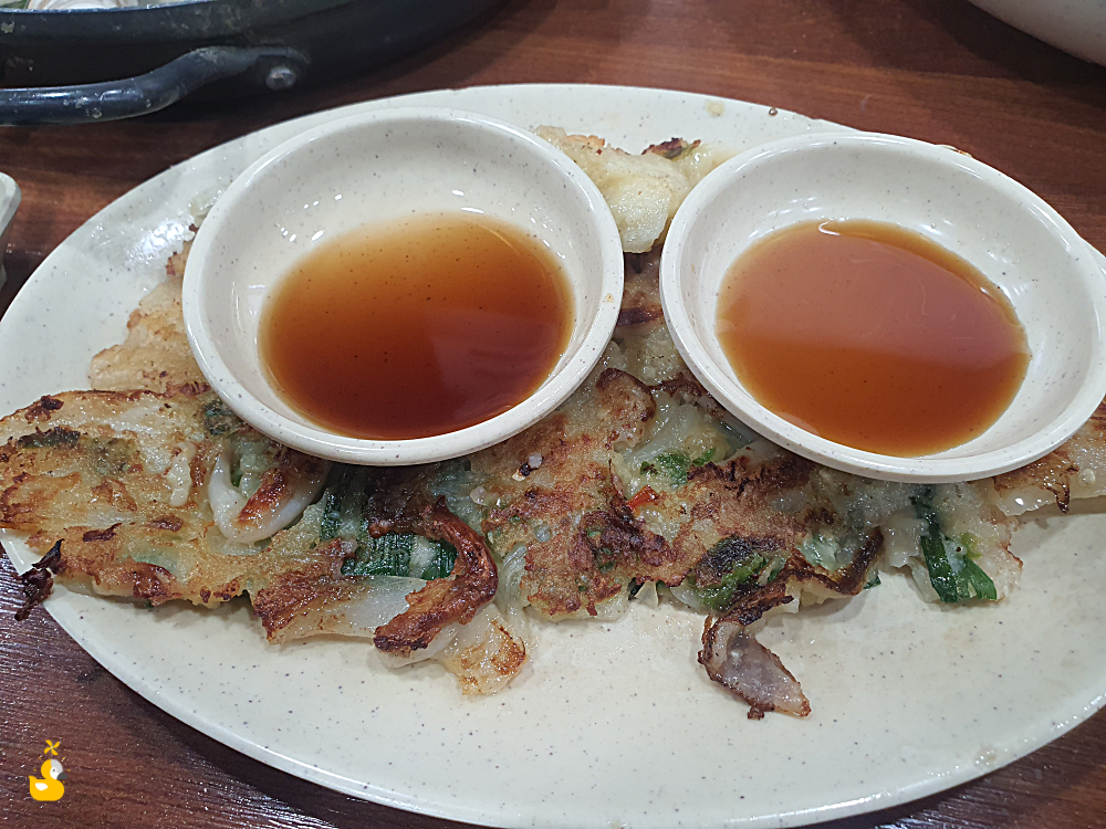 대전 오씨칼국수 도룡점 해물파전 반쪽 위에 얹어져 있는 간장 종지 2개