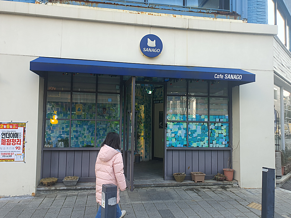 파란색 어닝과 간판이 돋보이는 사나고 카페 외관
