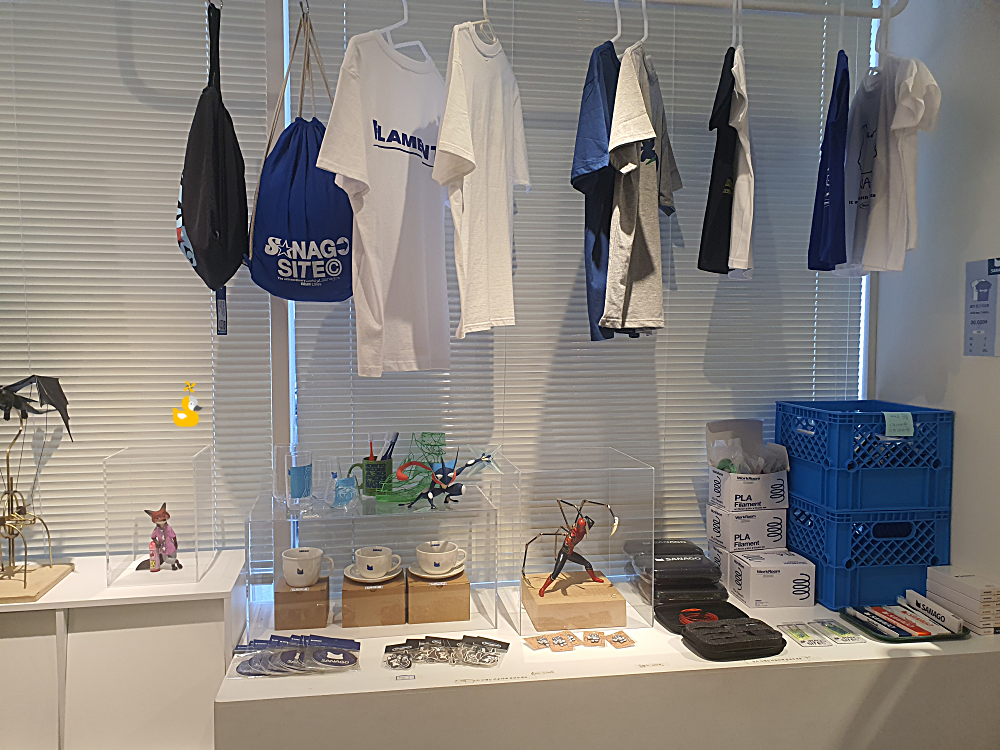 사나고 카페에서 판매 중인 티셔츠와 에코백 등 굿즈가 전시되어 있는 곳