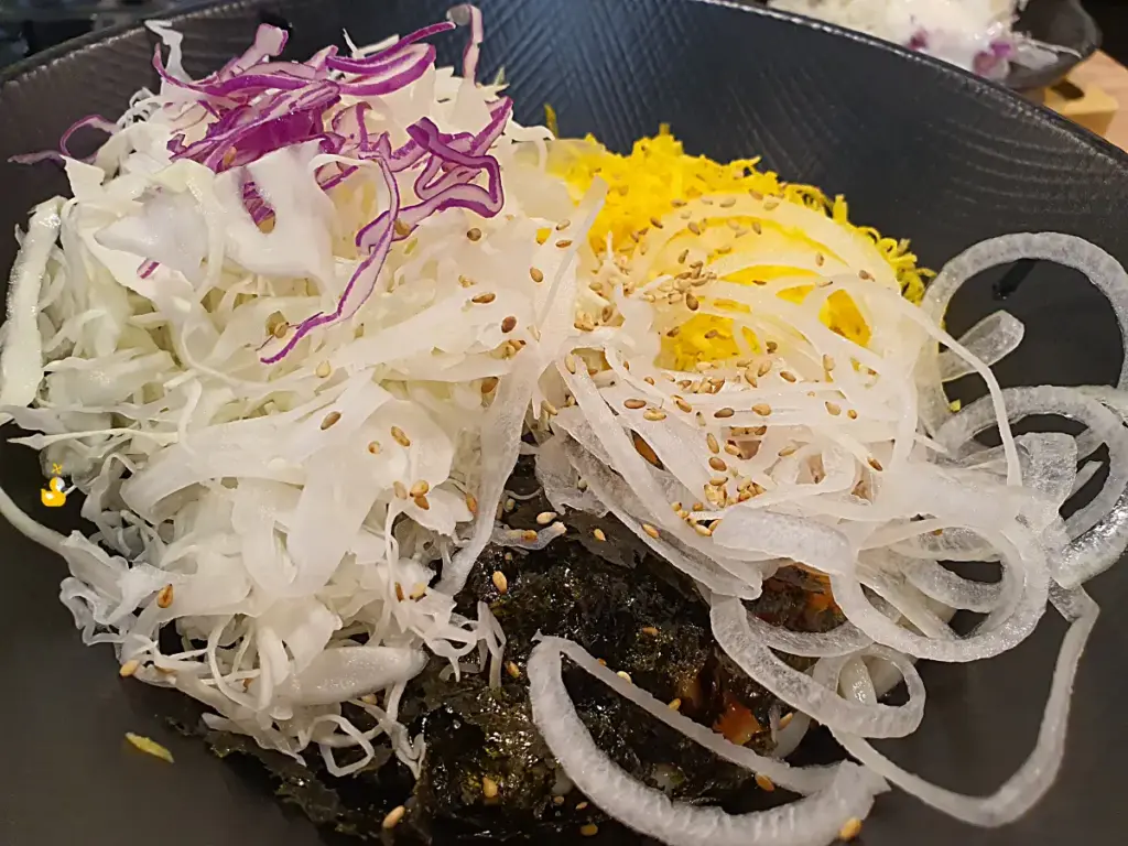 양배추와 계란지단, 양파와 김가루가 잔뜩 올려진 쑝쑝돈까스 비빔우동