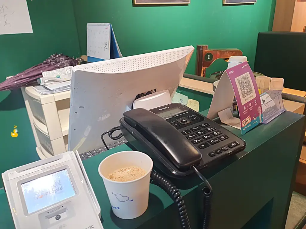 담가화로구이 무거점 카운터 위에 울산페이QR 안내판과 전화기 등이 올려져 있는 모습