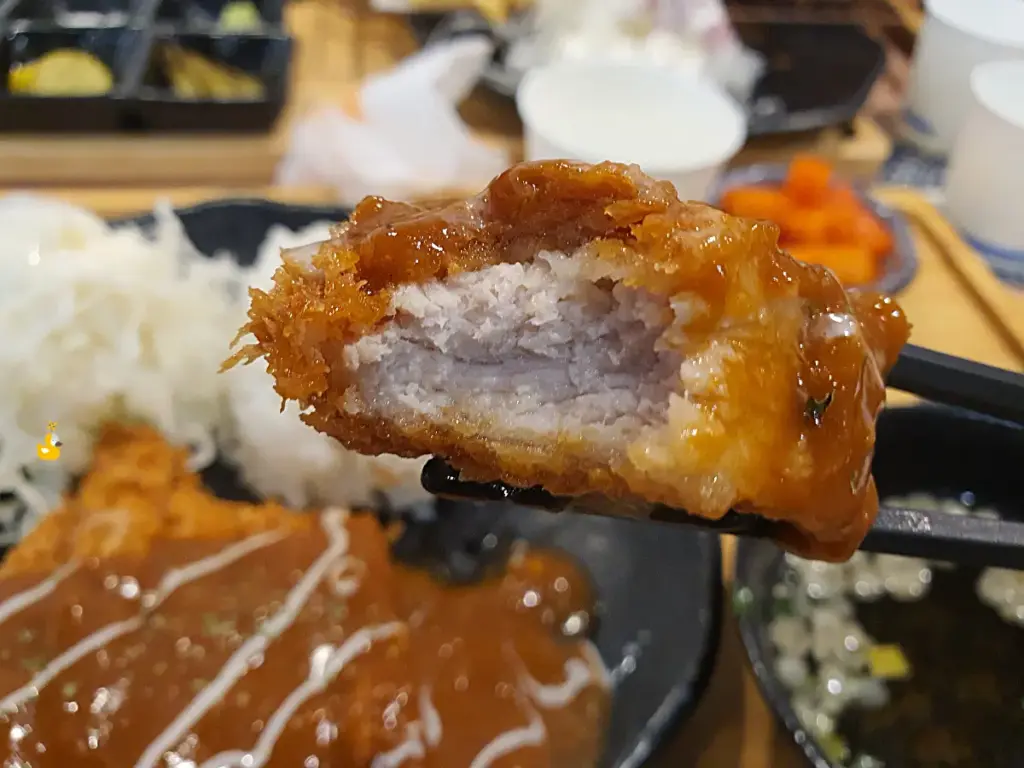 경양식 돈까스 한 조각을 베어 물어 도톰한 고기가 보여지는 모습