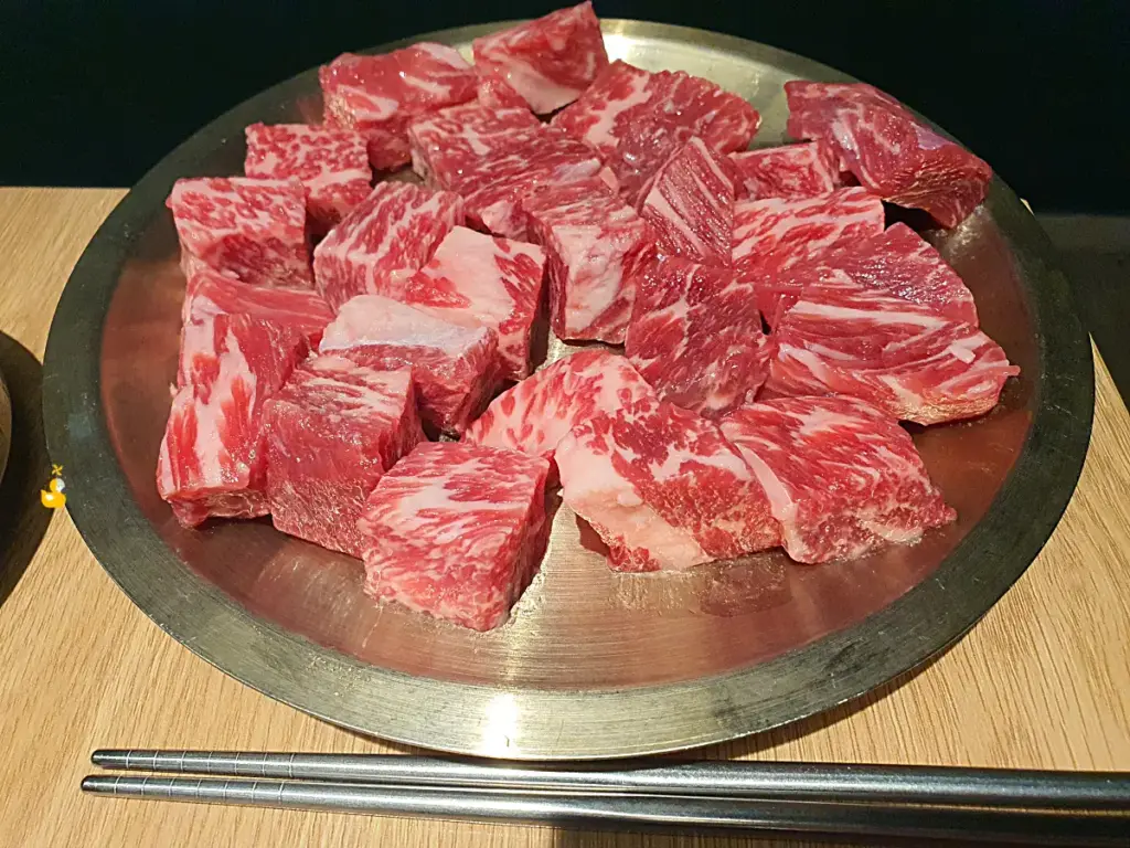 마블링이 예쁜 담가화로구이 무거점 소고기큐브눈꽃살이 금속 접시 위에 올려진 모습
