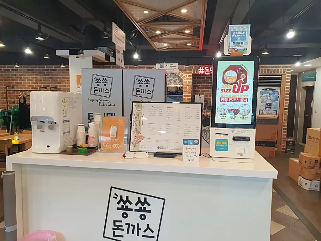 매장 입구 근처에 있는 키오스크와 메뉴판, 정수기 모습