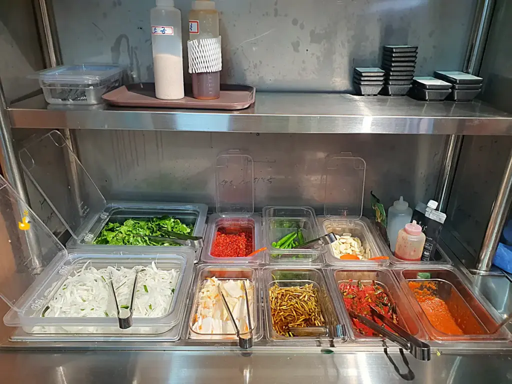 담가화로구이 무거점 셀프바에 양파채, 백김치 등 다양한 소스와 밑반찬이 채워져 있는 모습