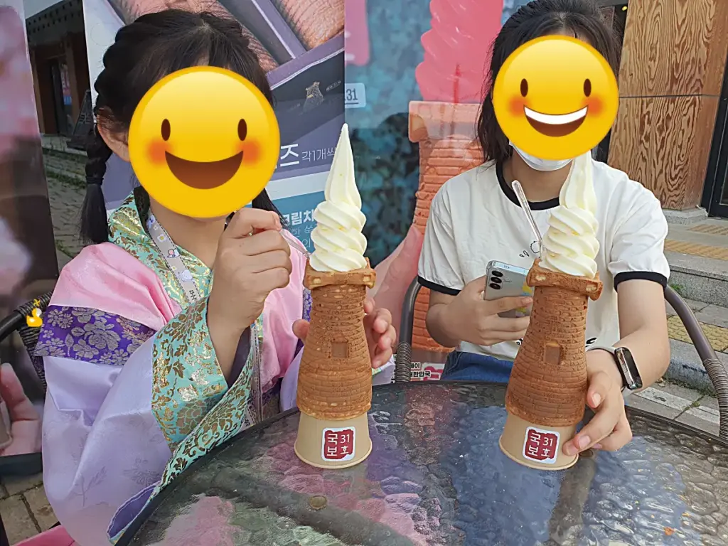 두 여자아이가 테이블에서 국보 31호 아이스크림을 먹으려는 모습